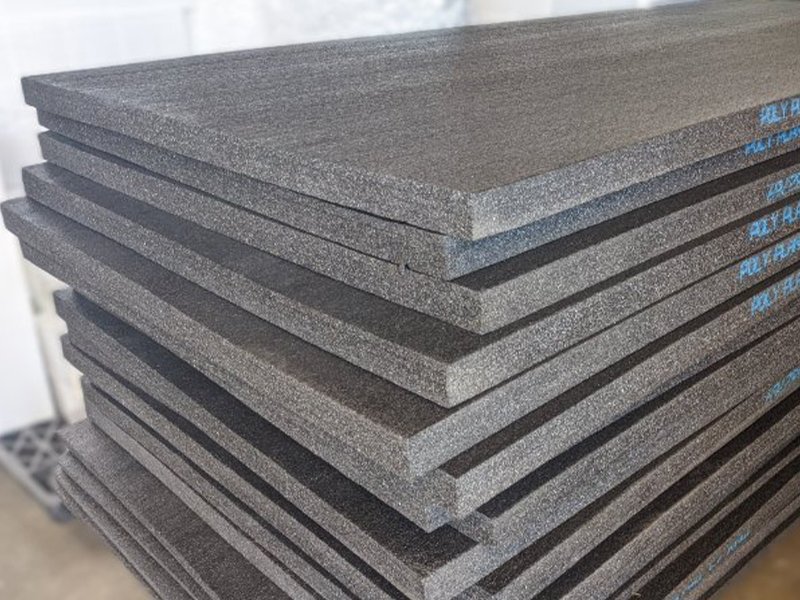 Black polyethlyene PE foam sheets that are 4' x 9' stacked in a pile